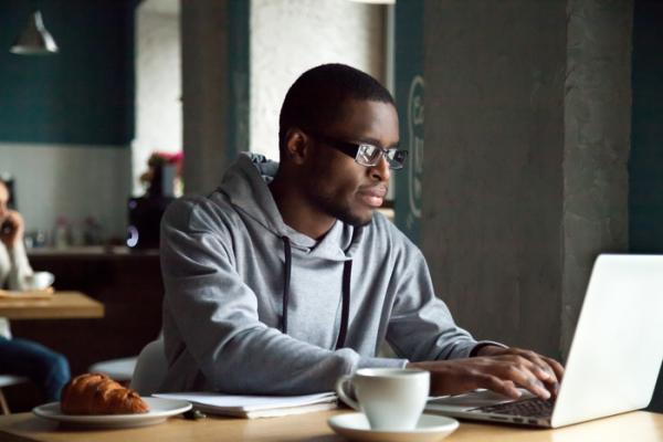 men working on laptop in cafe