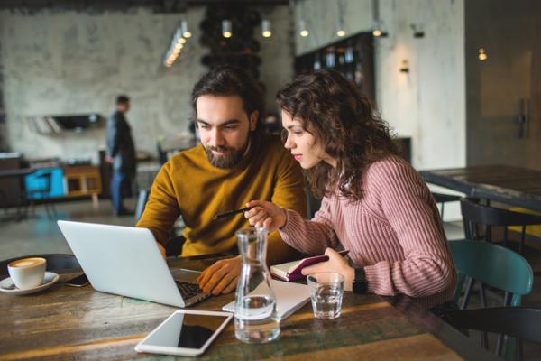 couple looking at laptop in coffee shop