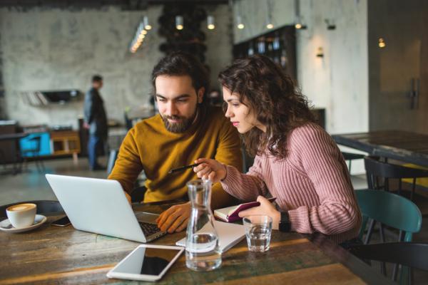 couple looking at laptop in coffee shop